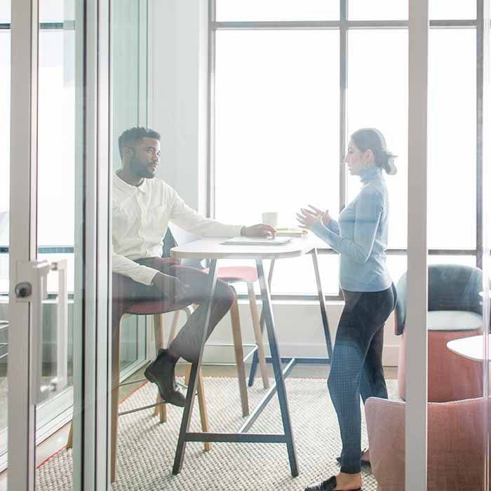 Man and woman collaborating in a meeting space in an office.