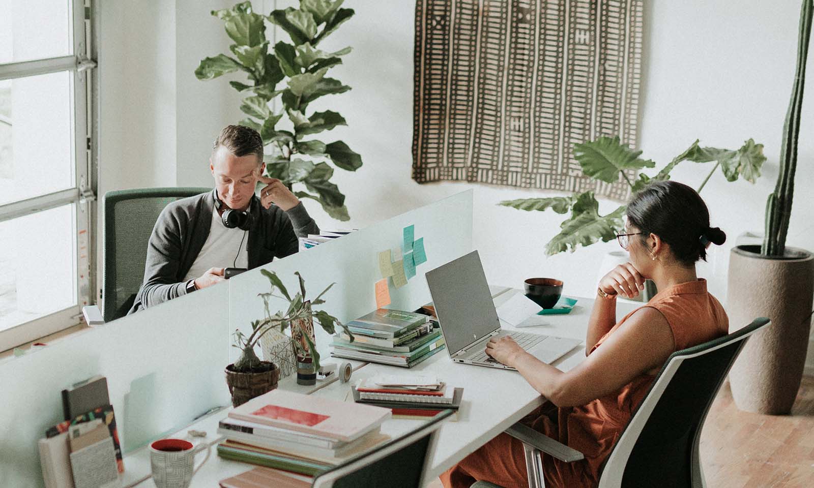 Man and woman sitting at workstations space in an office.