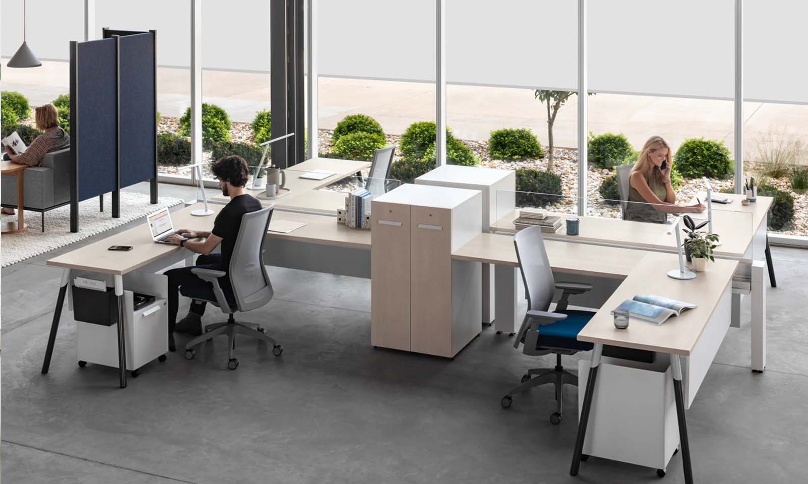 Man and woman sitting at workstations space in an office.