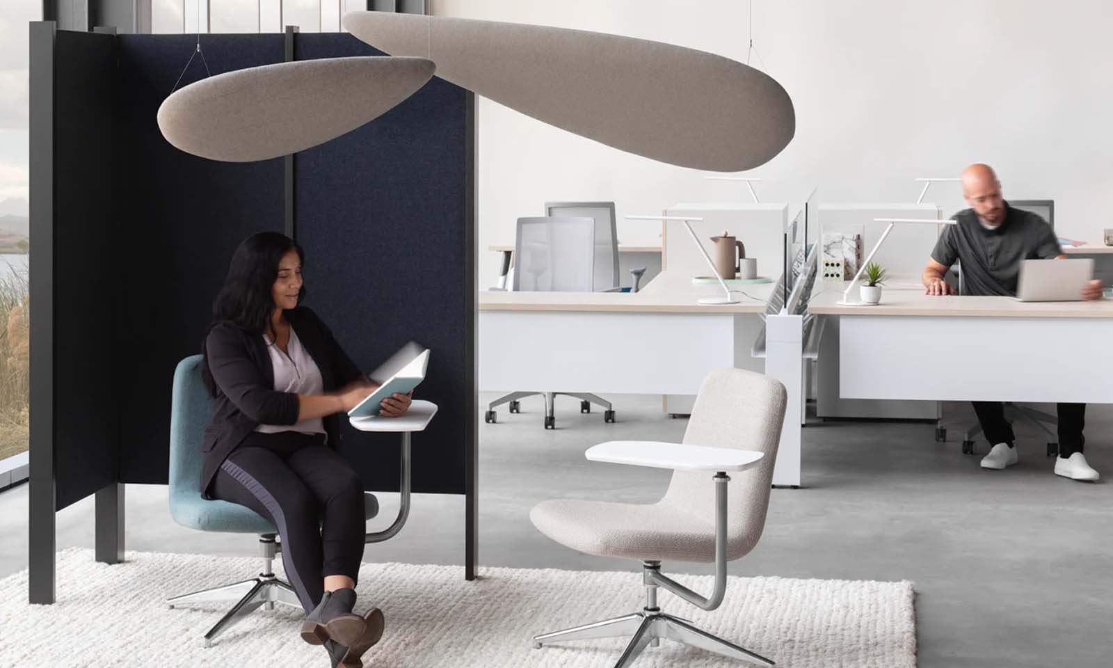 Man and woman sitting at workstations space in an office.