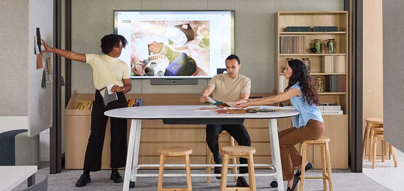 Colleagues conversing at a table in a work office