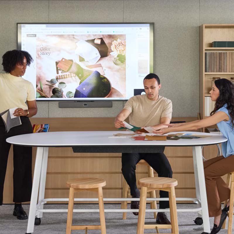 Colleagues conversing at a table in a work office